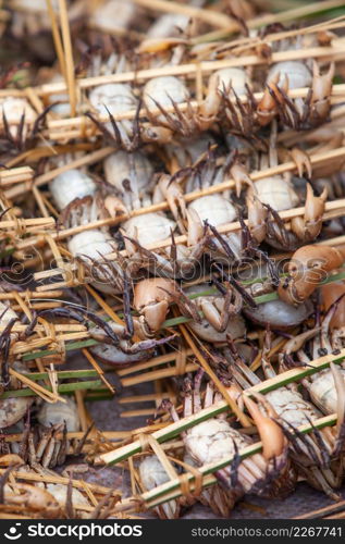 Wild crab in bamboo skewer on the basket, local food in Pakse, Laos PDR. Rainy season.