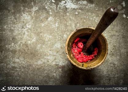 Wild raspberries in old mortar with pestle. On the stone table.. Wild raspberries in old mortar with pestle.