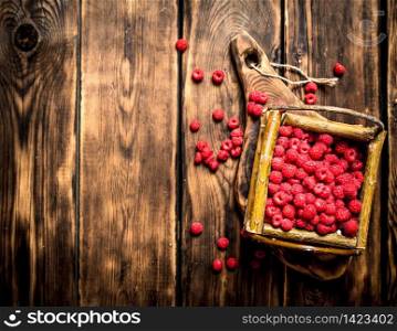 Wild raspberries in the basket. On a wooden table.. Wild raspberries in the basket.