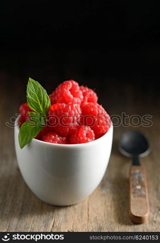 Wild raspberry in ceramic bowl and mint leaves