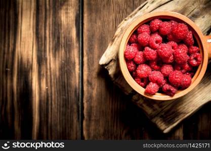 Wild raspberry in the Cup. On a wooden table.. Wild raspberry in the Cup.