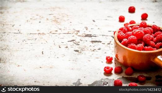 Wild raspberry in the Cup. On rustic background .. Wild raspberry in the Cup.