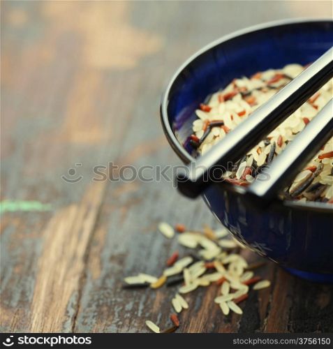 wild rice in ceramic bowl on wooden background