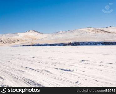 Wilderness of frozen water covered with snow in Lake Baikal near the snow mountain