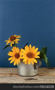 Wildflowers in an aluminum mug on a wooden table