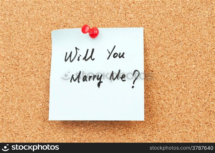 Will you marry me words written on paper and pinned on corkboard