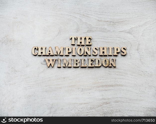 WIMBLEDON. Wooden, unpainted letters on a white table. Close-up, top view. Beautiful photo for invitation card. WIMBLEDON. Beautiful, bright photo for invitation card