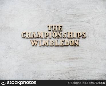 WIMBLEDON. Wooden, unpainted letters on a white table. Close-up, top view. Beautiful photo for invitation card. WIMBLEDON. Beautiful, bright photo for invitation card