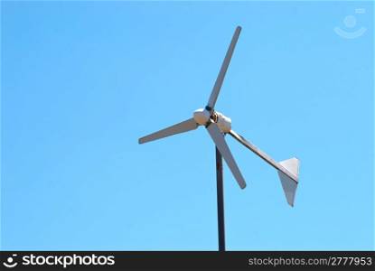 Wind electric turbine generator at blue sky background