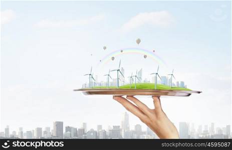 Wind energy. Hand holding metal tray with wind energy concept