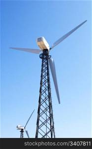 wind energy, modern white wind turbines in motion producing energy to power a city