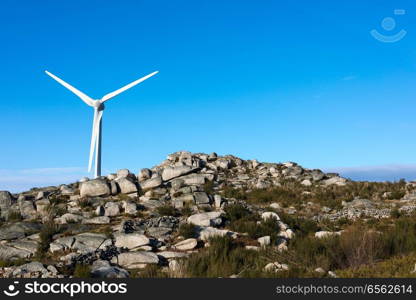 Wind energy turbines, in a landscpae over a beautiful blue sky