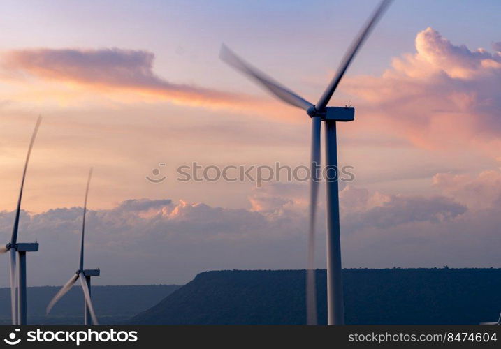 Wind energy. Wind power. Sustainable, renewable energy. Wind turbines generate electricity. Windmill farm on a mountain with sunset sky. Green technology. Renewable resource. Sustainable development.