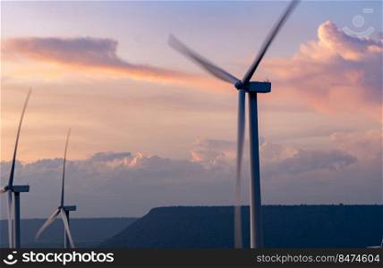 Wind energy. Wind power. Sustainable, renewable energy. Wind turbines generate electricity. Windmill farm on a mountain with sunset sky. Green technology. Renewable resource. Sustainable development.