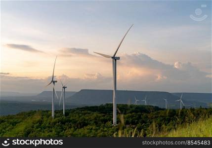 Wind energy. Wind power. Sustainable, renewable energy. Wind turbines generate electricity. Windmill farm on mountain with sunset sky. Green technology. Renewable resource. Sustainable development.