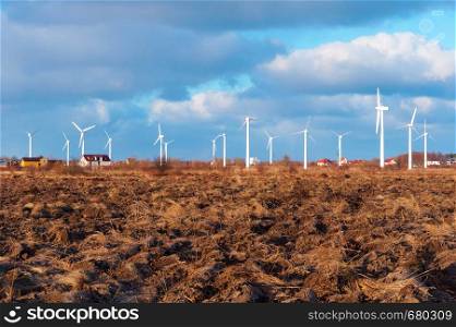 wind farm in the field, freshly plowed field, agricultural land and wind turbines. agricultural land and wind turbines, wind farm in the field, freshly plowed field