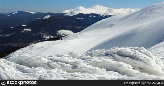 Wind form ice lumps on mountain landscape background (Ukraine, Carpathian Mt&rsquo;s, Goverla and Petros mount behind) Five shots stitch image.
