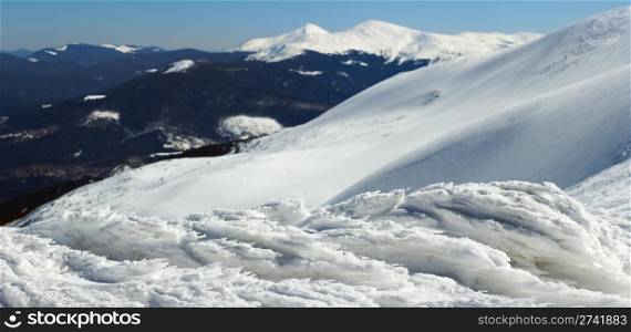 Wind form ice lumps on mountain landscape background (Ukraine, Carpathian Mt&rsquo;s, Goverla and Petros mount behind) Five shots stitch image.