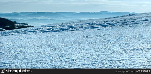 Wind form ice texture on winter mountain snow surface in contra light direction - with sun catchlights.