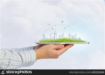 Wind generators. Hands holding digital tablet with energy concept