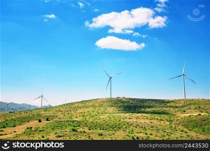 Wind generators on a plain under a blue sky. Wind power station. Clean fuel concept. Wind generators on a plain under a blue sky