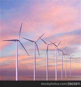 Wind generators turbines in the sea on sunset