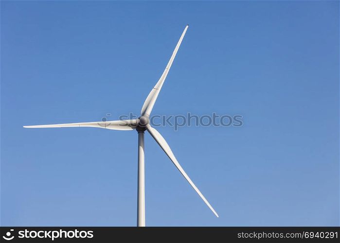 Wind power turbine close up view over blue sky
