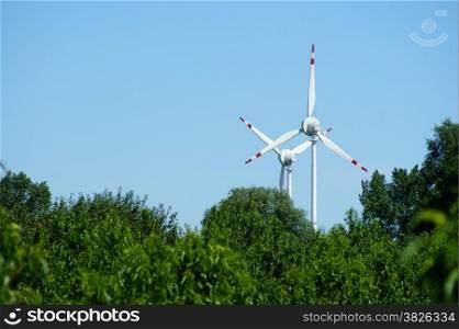 Wind power turbine, forest - blue sky