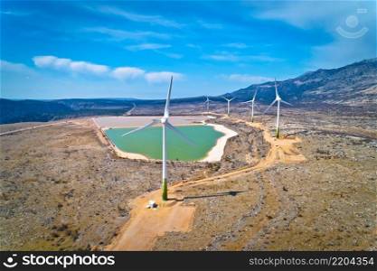 Wind power turbines under Velebit mountain view, Alkaline pool from abandoned factory, Dalmatia region of Croatia