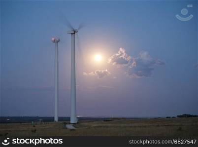 Wind station turbines and full moon at the sky