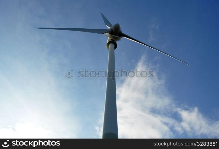 Wind turbine as alternative energy source against blue cloudy sky