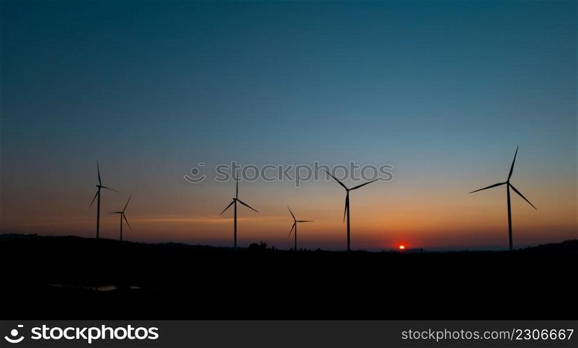 wind turbine field at beautiful sunset sky background. renewable energy