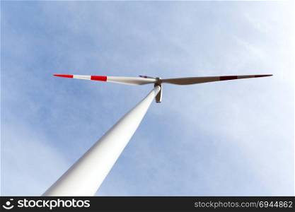 Wind turbine from below against blue sky
