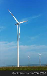 wind turbine generating eco friendly renewable electricity energy on blue sky
