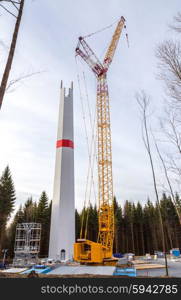 Wind turbine is built with a crane in wind farm. Wind turbine is built with a crane in wind farm.