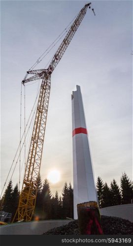 Wind turbine is built with a crane in wind farm. Wind turbine is built with a crane in wind farm.