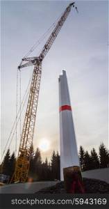 Wind turbine is built with a crane in wind farm. Wind turbine is built with a crane in wind farm.