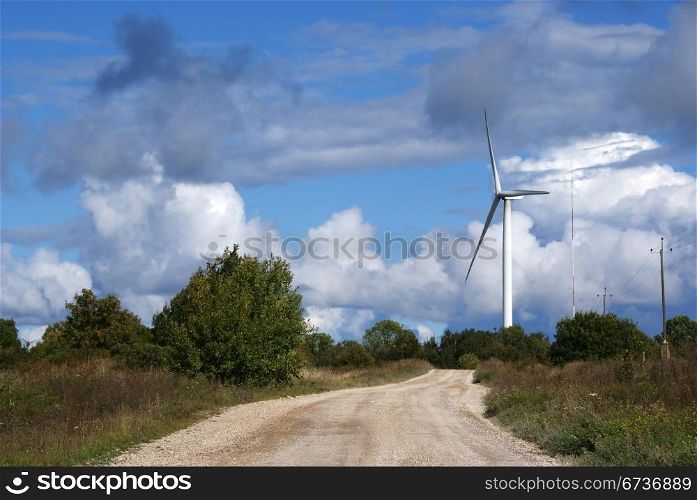 Wind turbine on a background of the blue sky and clouds