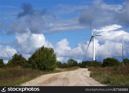 Wind turbine on a background of the blue sky and clouds