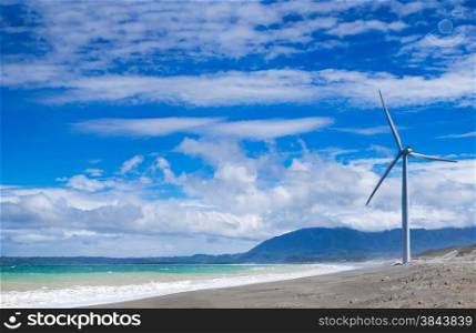 Wind turbine power generators silhouettes at ocean coastline. Alternative renewable energy production in Philippines