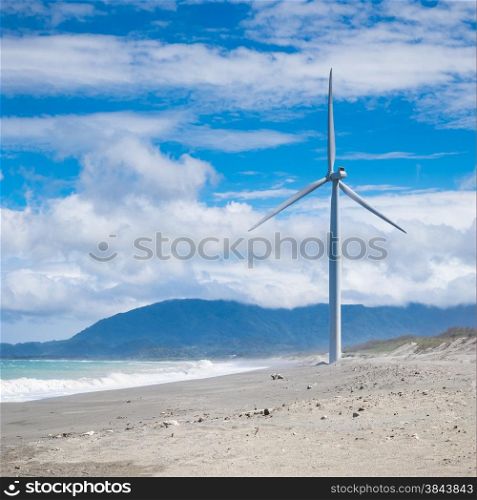Wind turbine power generators silhouettes at ocean coastline. Alternative renewable energy production in Philippines