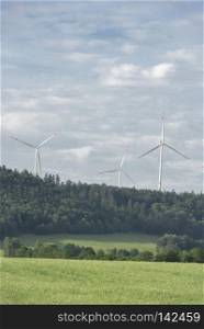 Wind turbines at horizon over the forest under a blue sky, near the german city, Schwabisch Hall