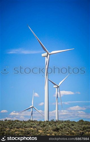 wind turbines generating electricity on a windy sunny day