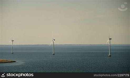 Wind turbines generator farm for renewable sustainable and alternative energy production along coast baltic sea near Denmark. Eco power, ecology.. wind turbines farm on coast