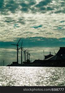 Wind turbines generator farm for renewable sustainable and alternative energy production along coast baltic sea near Denmark. Eco power, ecology.. Wind turbines power generator farm along coast sea