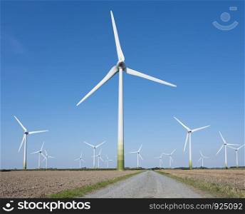 wind turbines in agriculture landscape of ostfriesland in the north of ostfriesland in lower saxony and blue sky