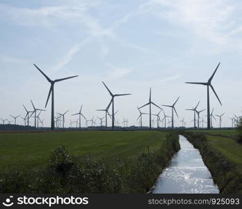 wind turbines in agriculture landscape of ostfriesland in the north of ostfriesland in lower saxony and blue sky