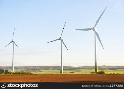 wind turbines in fields under blue sky