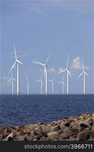 wind turbines in water of ijsselmeer off the coast of flevoland with blue sky in the netherlands