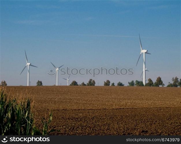 wind turbines on farmland. wind turbines on farmland with fresh field in the forground